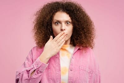 woman covers her mouth with her hand